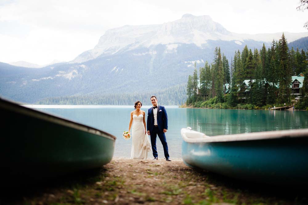 sophisticated picturesque wedding - bride and groom with canoes